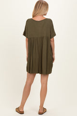 woman wearing an olive green short sleeve dress with a relaxed fit and gathered waist, viewed from the back