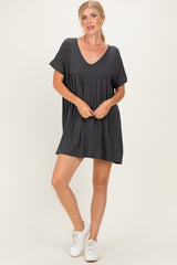 woman wearing a dark gray short sleeve mini dress with a v-neck and relaxed fit, paired with white sneakers