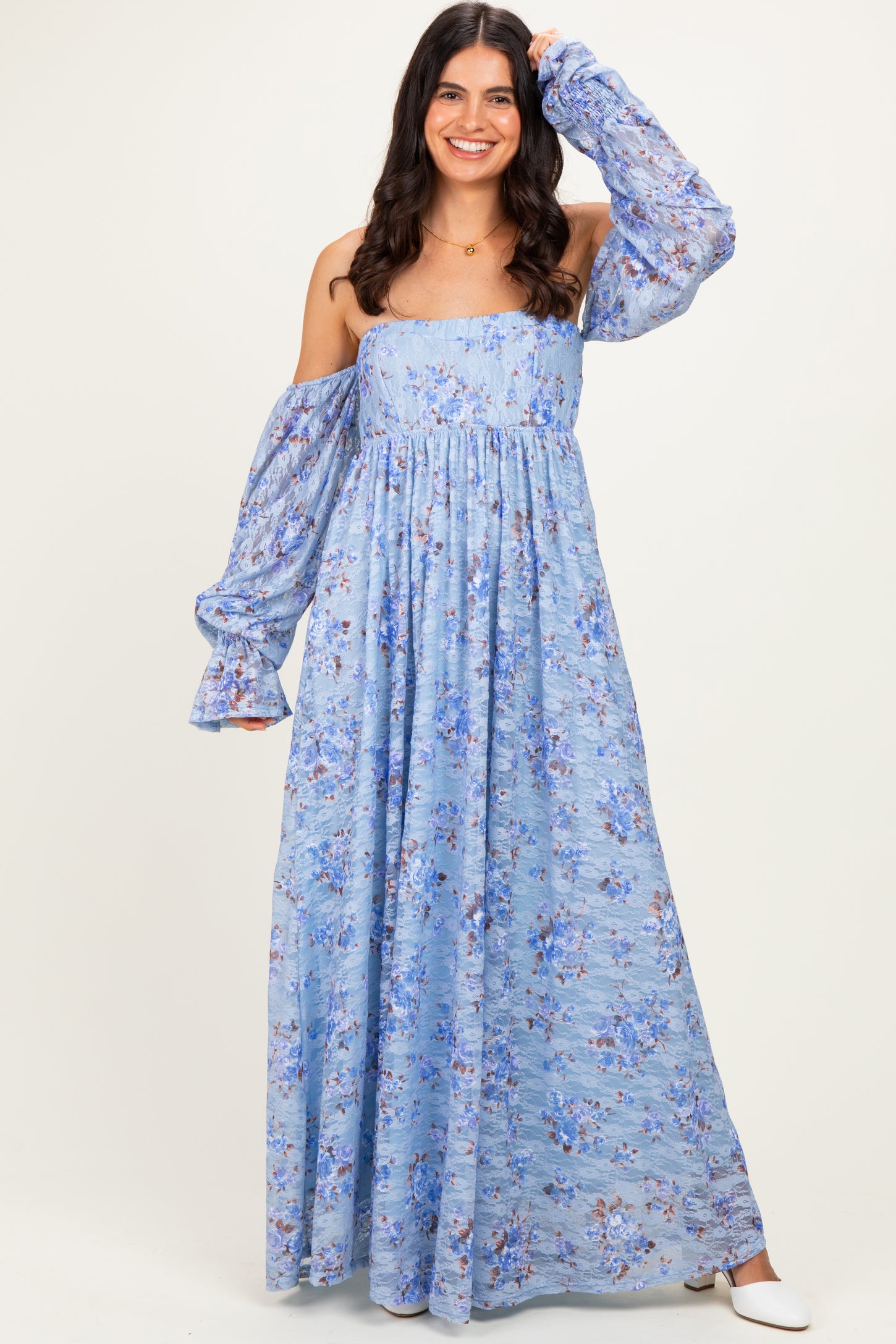 woman wearing a light blue off-shoulder maxi dress with floral print and long puff sleeves