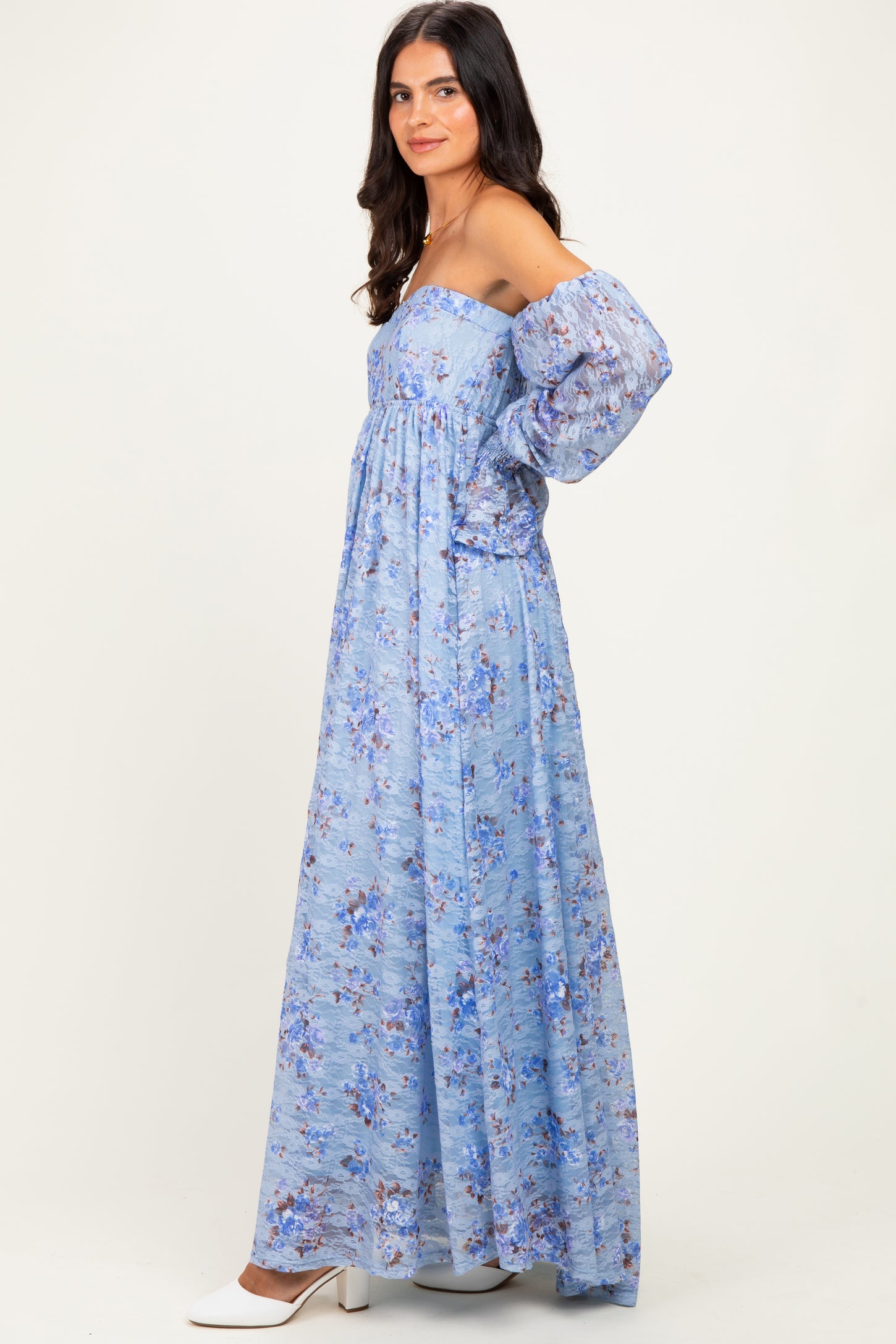 woman wearing a light blue off-the-shoulder maxi dress with floral print and puff sleeves