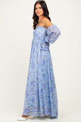 woman wearing a light blue off-the-shoulder maxi dress with floral print and puff sleeves