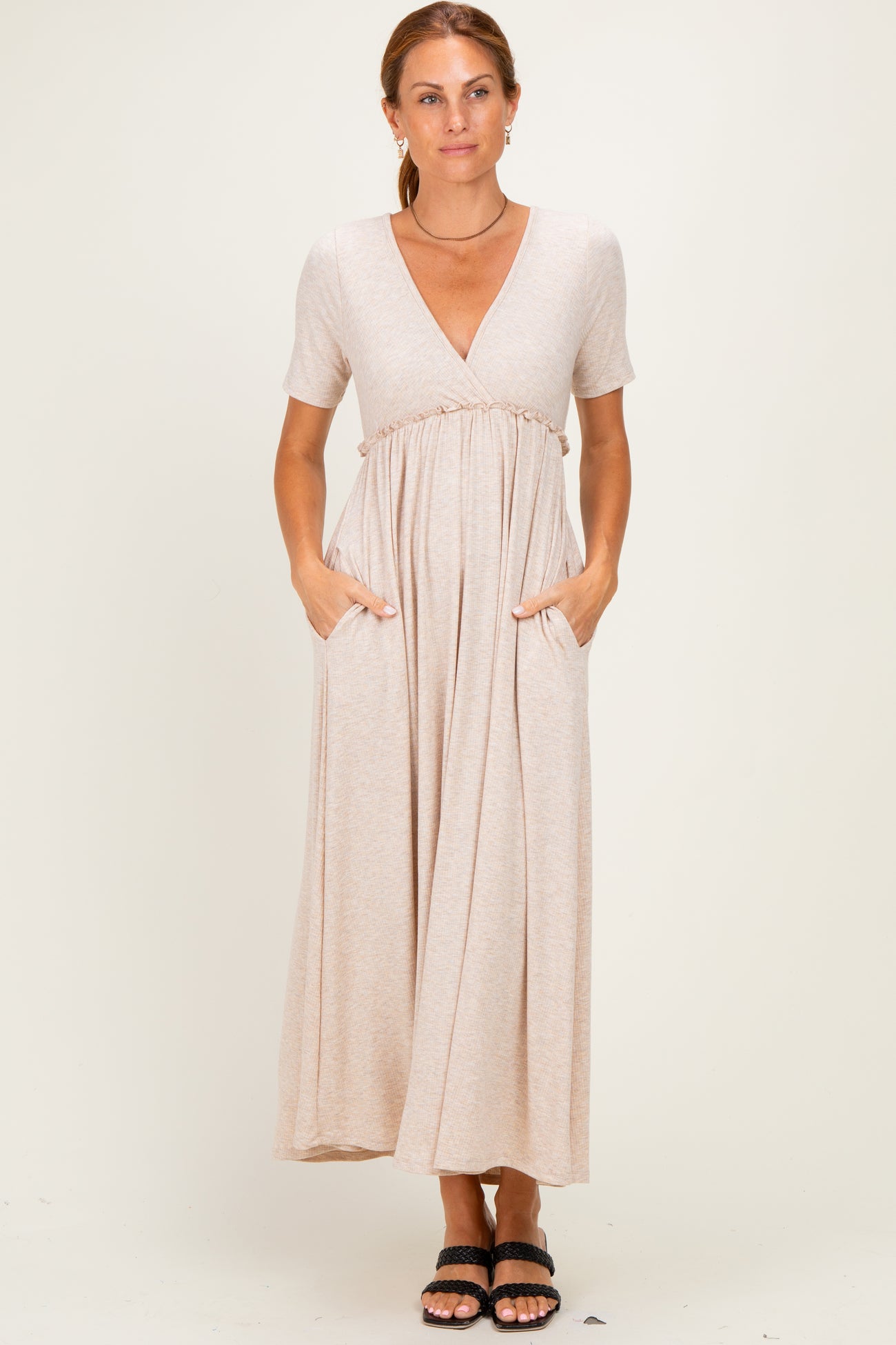 woman wearing a beige short sleeve maxi dress with a v-neck and pockets