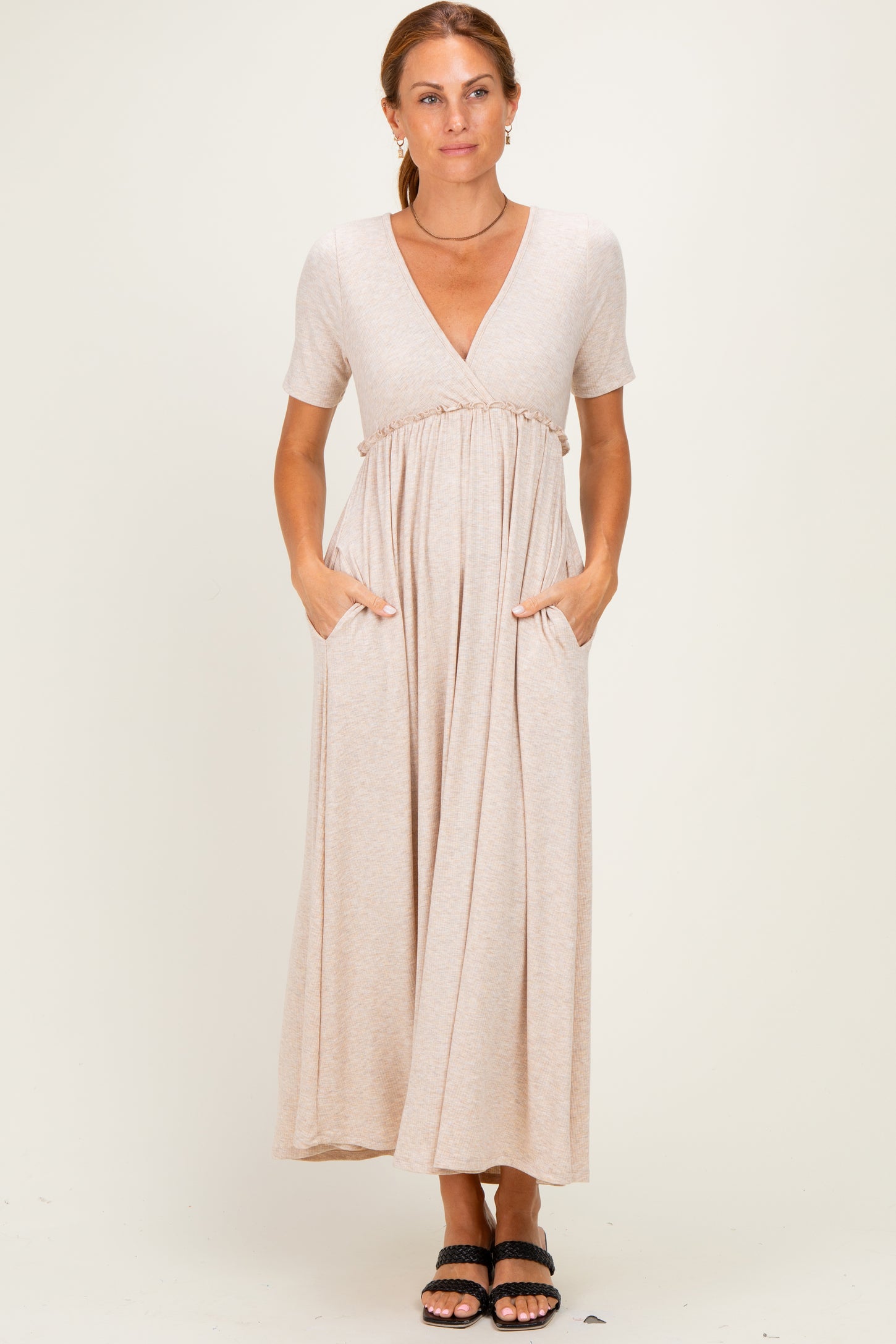 woman wearing a beige short sleeve maxi dress with a v-neck and pockets