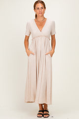 woman wearing a beige short sleeve maxi dress with a v-neck and pockets