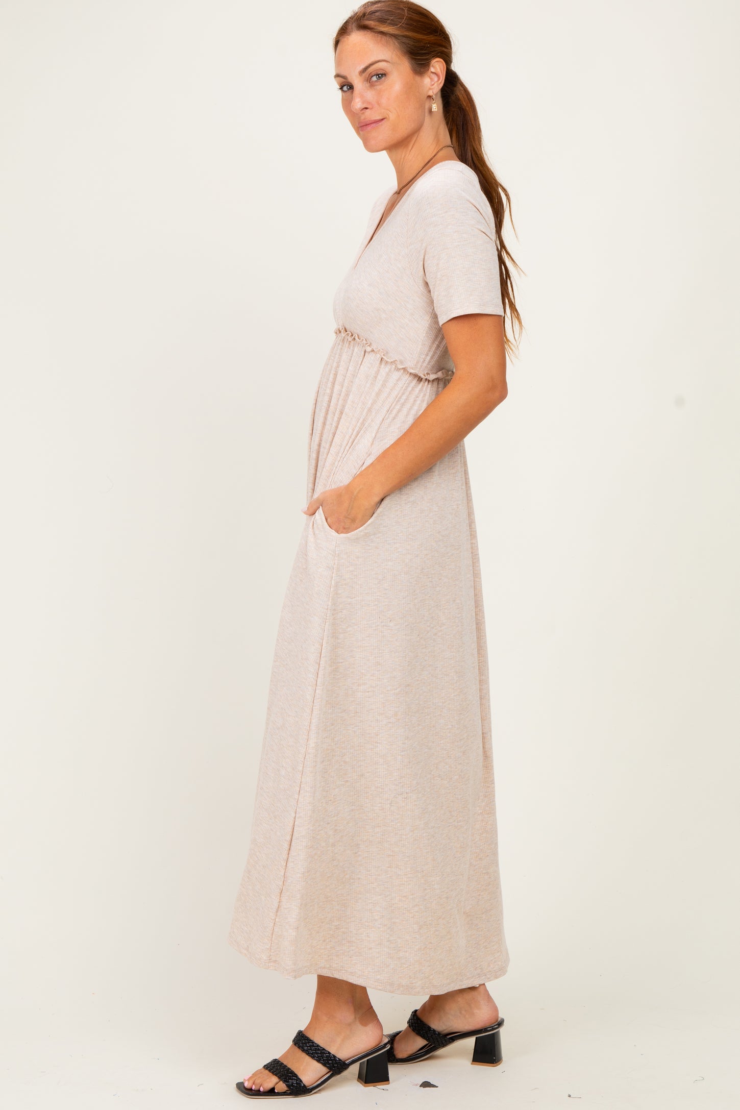 woman wearing a beige short sleeve maxi dress with side pockets and a cinched waist
