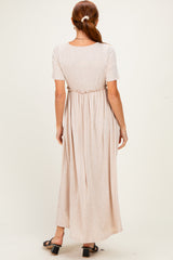 woman wearing a light beige maxi dress with short sleeves and cinched waist, viewed from the back