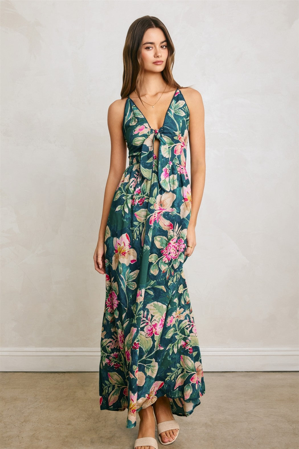woman wearing a floral maxi dress with a tie front and a deep V-neckline, styled with strappy sandals