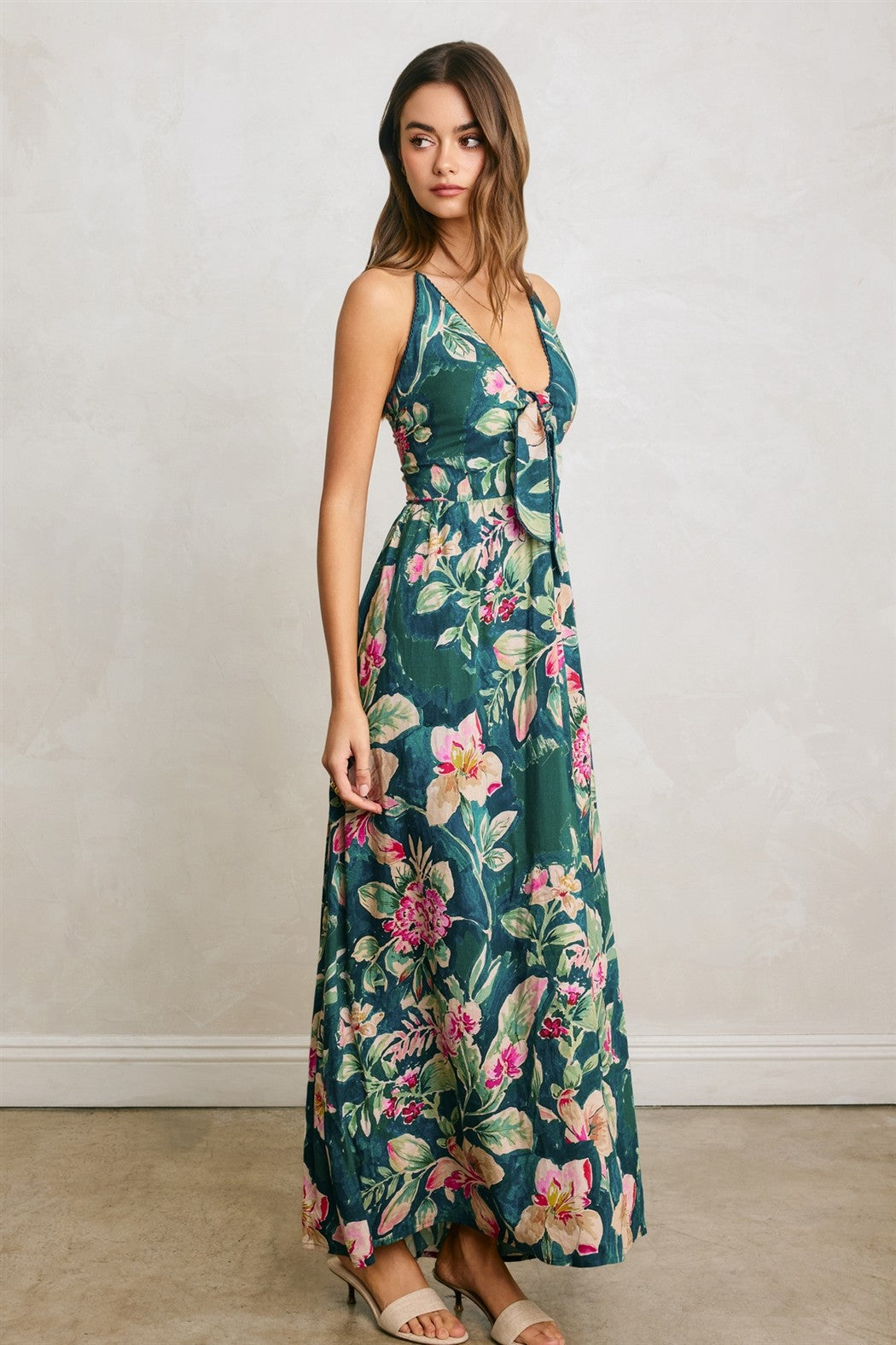 woman wearing a teal floral maxi dress with a tie front detail and spaghetti straps