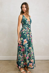 woman wearing a teal floral maxi dress with a tie front detail and spaghetti straps