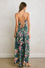 woman wearing a floral maxi dress with a crisscross back detail and a flowy skirt