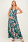 woman wearing a green floral maternity maxi dress and holding her baby bump