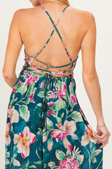 woman wearing a floral maternity dress with crisscross back details and a flowy skirt