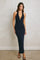 woman wearing a navy blue halter neck maxi dress with a keyhole detail and fitted silhouette