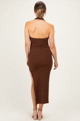 woman wearing a brown ribbed maternity dress with a side slit, showing a pregnant baby bump from the back