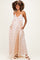 woman wearing a peach polka dot maternity maxi dress with adjustable straps and side pockets, showcasing her baby bump