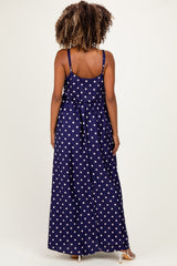woman wearing a navy blue polka dot maxi maternity dress, showing the back view and adjustable straps