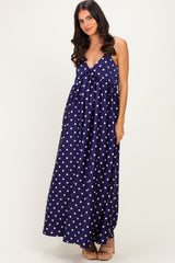 woman wearing a navy blue maxi dress with white polka dots and a tie front detail