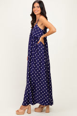 woman wearing a navy blue polka dot maxi dress with pockets and a relaxed fit, posing sideways
