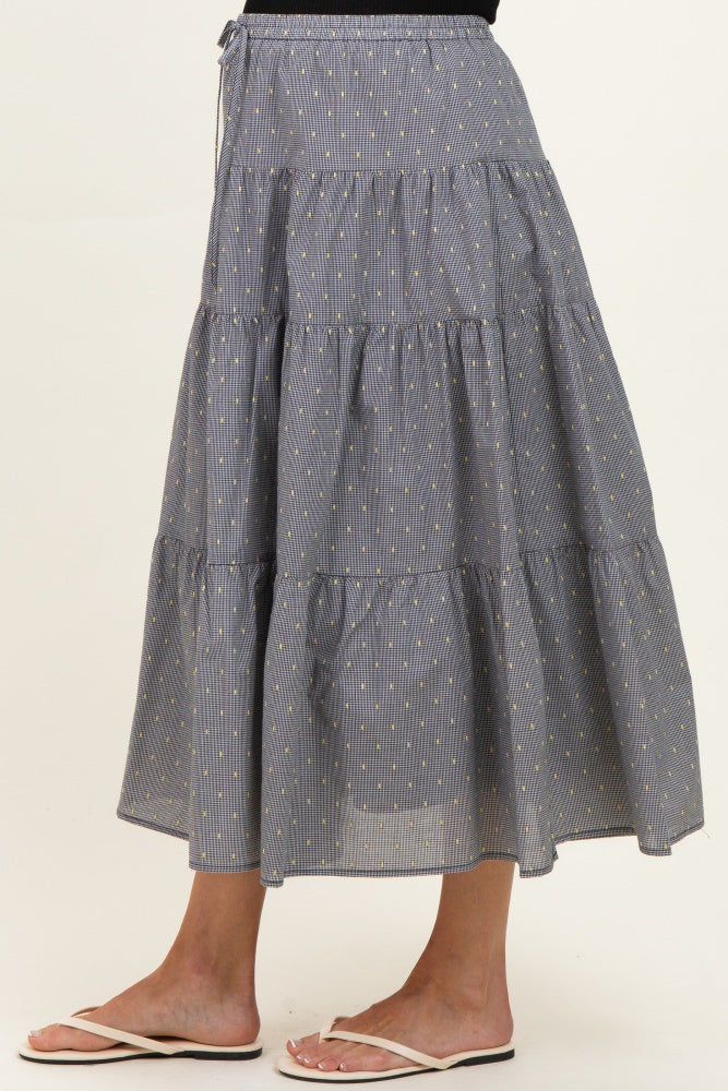 woman wearing a navy blue tiered maternity maxi skirt with yellow stripes and a comfortable elastic waistband