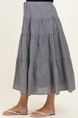 woman wearing a navy blue tiered maternity maxi skirt with yellow stripes and a comfortable elastic waistband