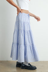woman wearing a light blue tiered maxi skirt with red floral print