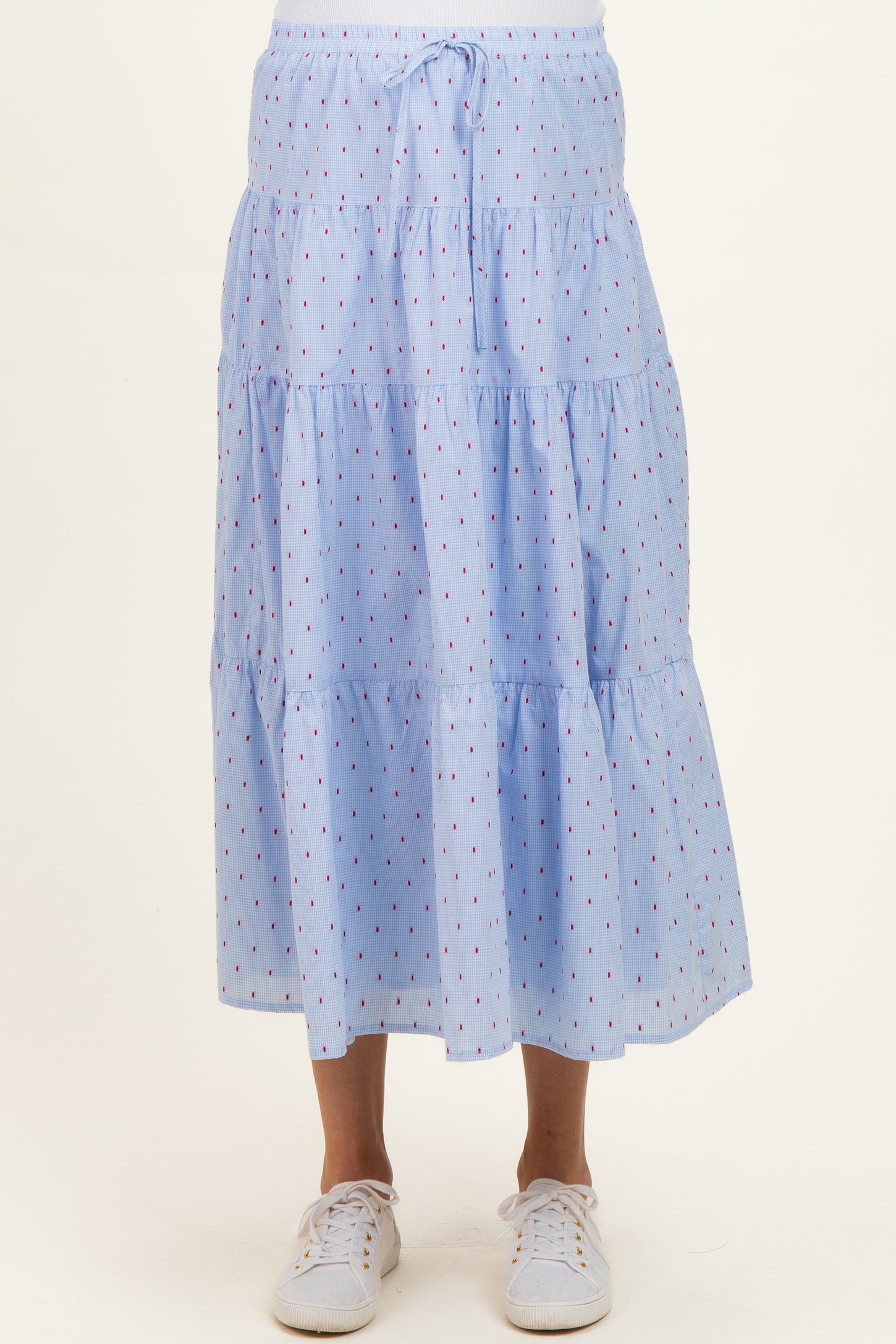light blue maternity maxi skirt with tiered design and red polka dots, worn with white sneakers