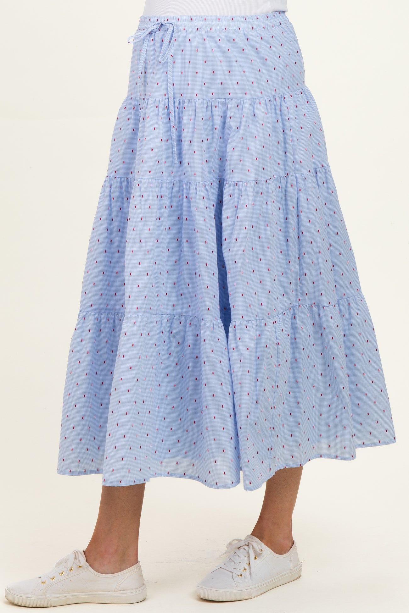 maternity wear light blue tiered maxi skirt with red dot pattern, worn with white sneakers