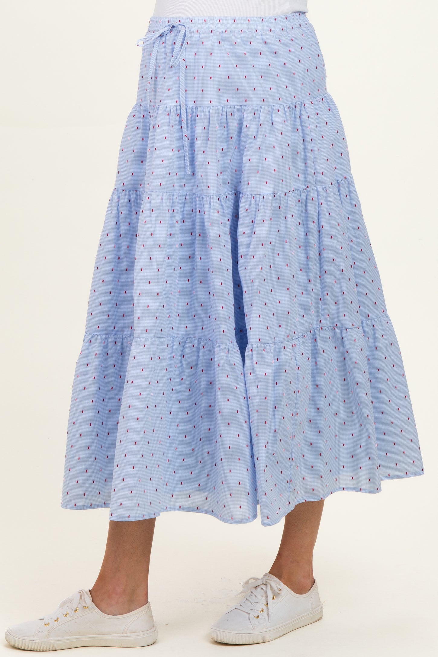 maternity wear light blue tiered maxi skirt with red dot pattern, worn with white sneakers