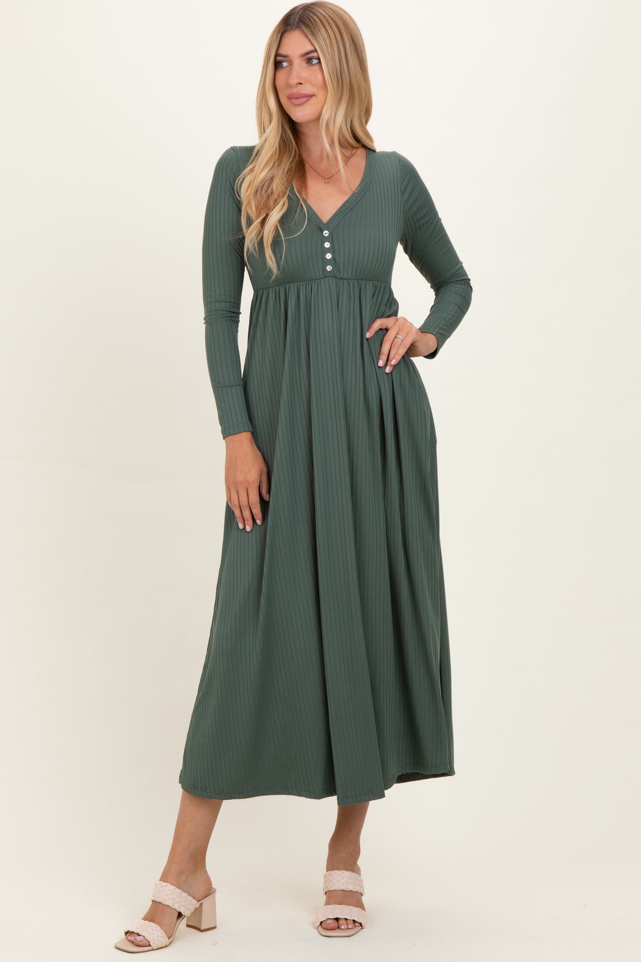 woman wearing a dark green ribbed maxi dress with long sleeves and button details