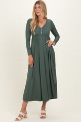 woman wearing a dark green ribbed maxi dress with long sleeves and button details