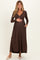 woman wearing a chocolate brown long sleeve maternity dress with buttons and side pockets, highlighting her baby bump
