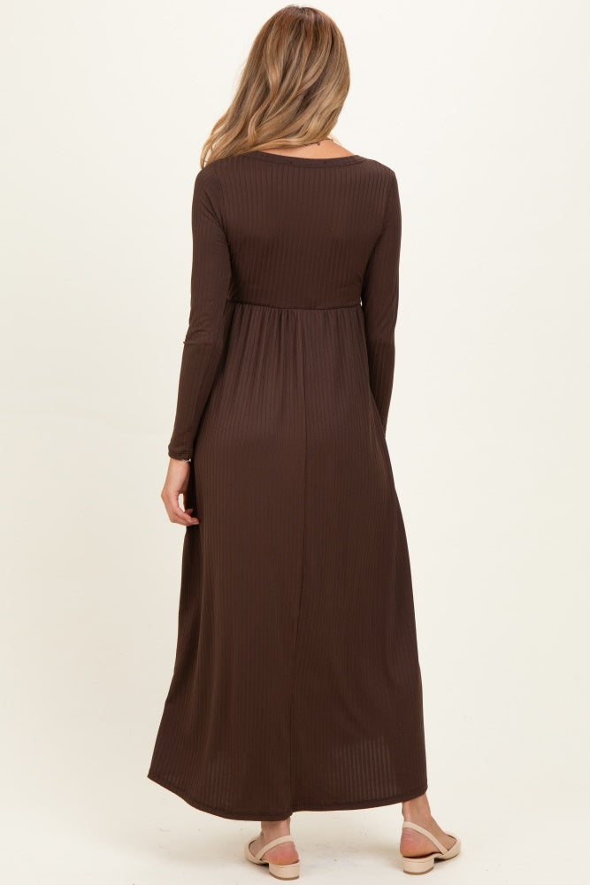 woman wearing a brown long sleeve maternity dress with a fitted waist and flowing skirt, viewed from the back