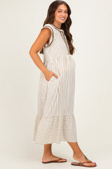 woman wearing a cream and tan striped maternity dress with a tiered hem and pockets, showcasing her baby bump