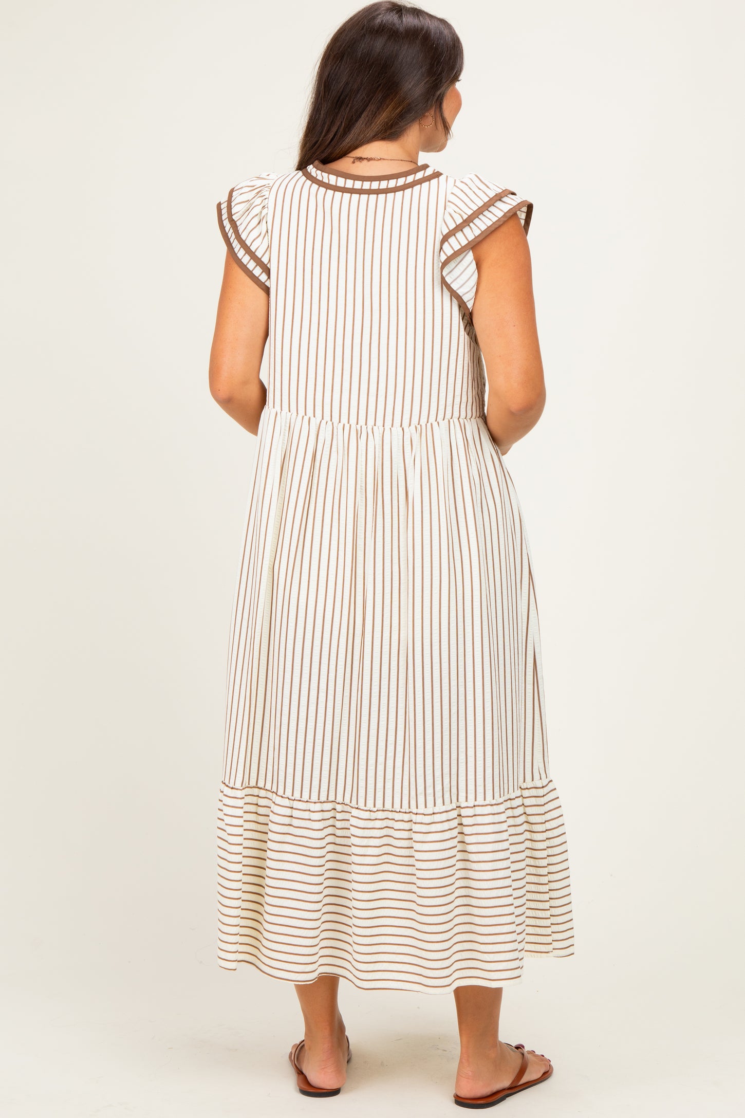 woman wearing a striped maternity maxi dress with ruffled sleeves, showing the back view