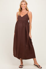 woman wearing a brown maternity maxi dress with adjustable straps and a flowy fit, baby bump visible
