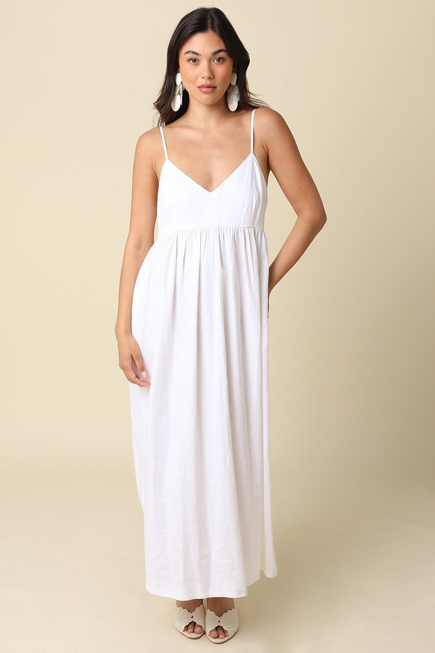 woman wearing a white maxi dress with adjustable spaghetti straps and a flowy silhouette
