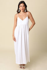 woman wearing a white maxi dress with adjustable spaghetti straps and a flowy silhouette