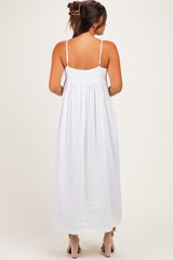 woman wearing a white maternity maxi dress with adjustable straps, showing the back view