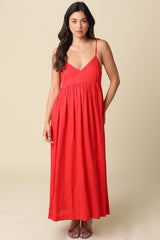 woman wearing a red spaghetti strap maxi dress with a fitted bodice and flowy skirt