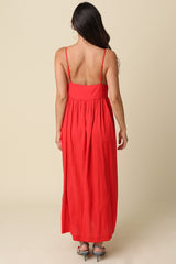 woman wearing a back-view of a red maxi dress with thin straps and a gathered waistline