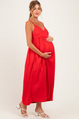 woman wearing a red maternity maxi dress with a v-neckline and holding her baby bump