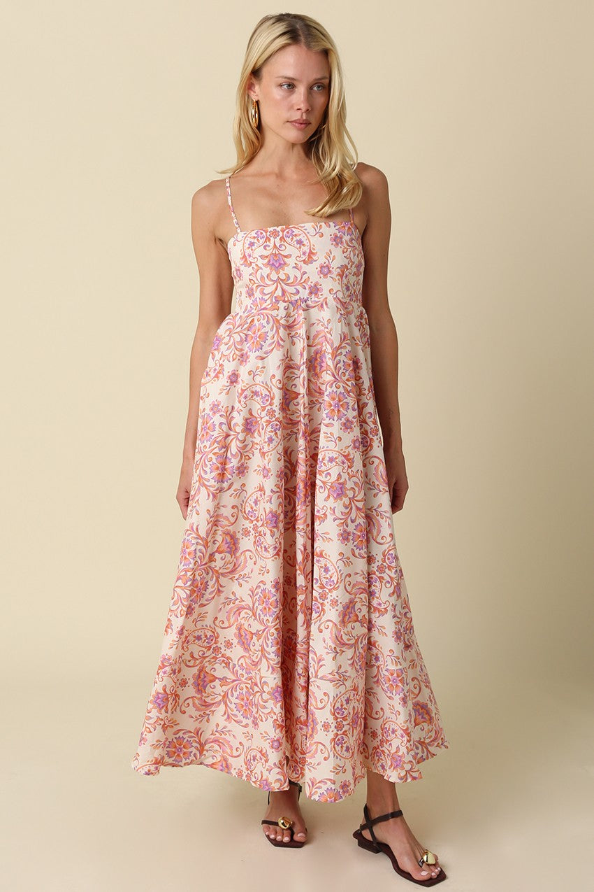 woman wearing a floral print maxi dress with thin straps and a flowing silhouette