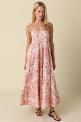 woman wearing a floral print maxi dress with thin straps and a flowing silhouette