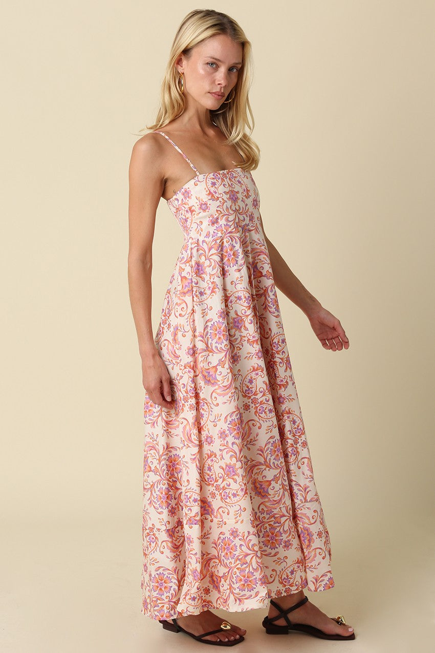 woman wearing a long pink floral maxi dress with spaghetti straps and a flared skirt