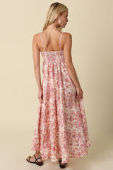 woman wearing a backless floral maxi dress with thin straps and a flowing skirt