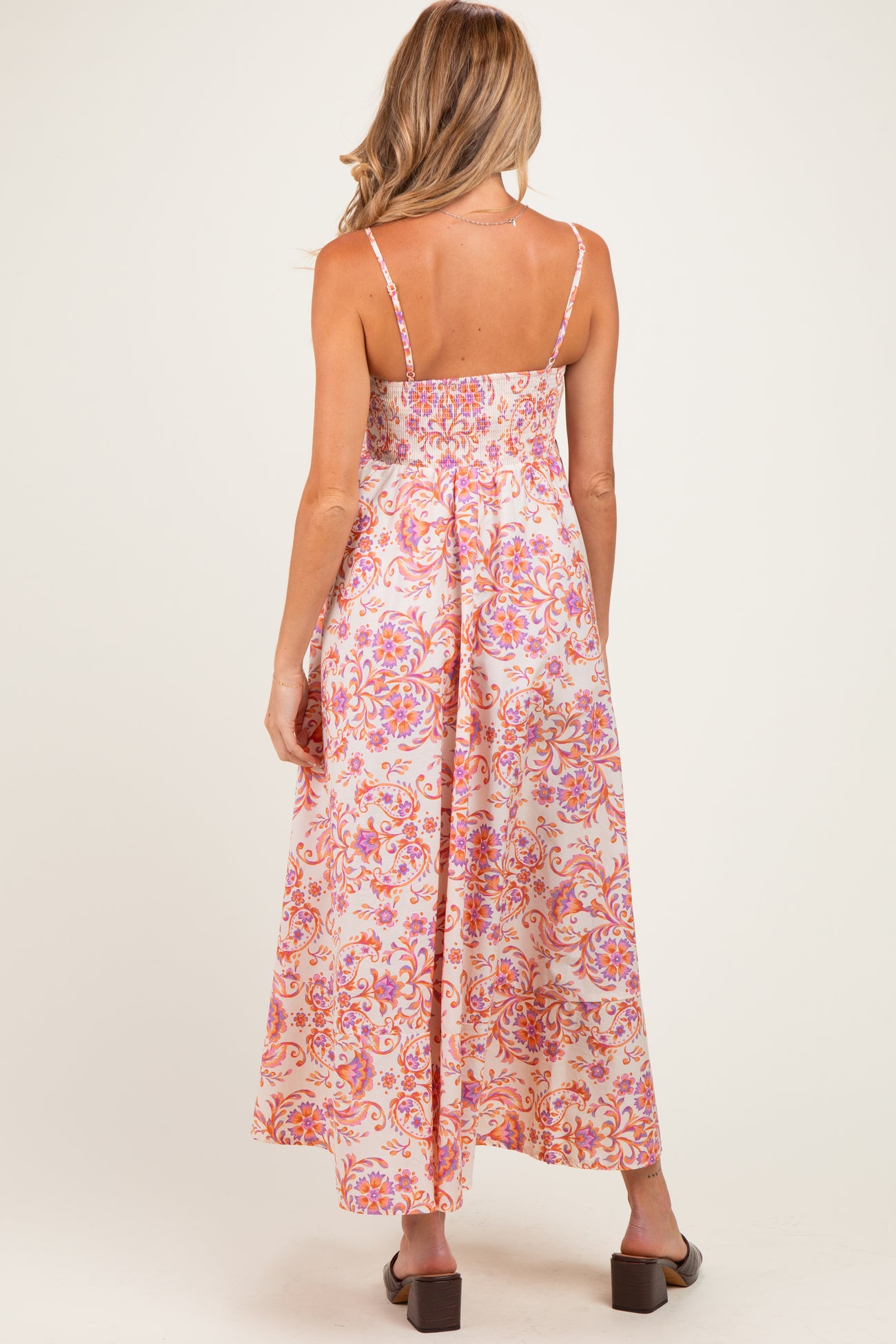 woman wearing a floral print maternity maxi dress with adjustable straps and a smocked back, showing a relaxed fit