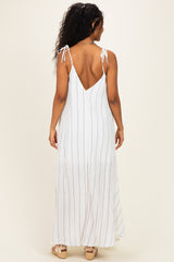 woman wearing a white and blue striped maternity maxi dress with tie straps and a low back