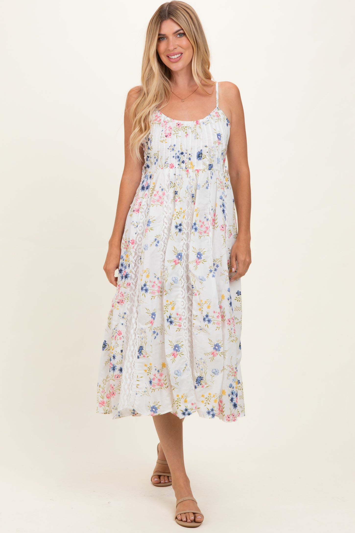woman wearing a white floral maxi dress with spaghetti straps and a flowy silhouette