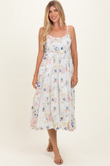 woman wearing a white floral maxi dress with spaghetti straps and a flowy silhouette