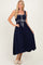 woman wearing a navy blue maxi dress with ruffled straps and a belted waist detail